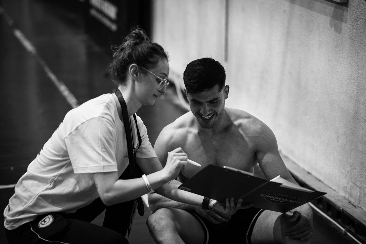 A trainer and participant looking at a clipboard together.