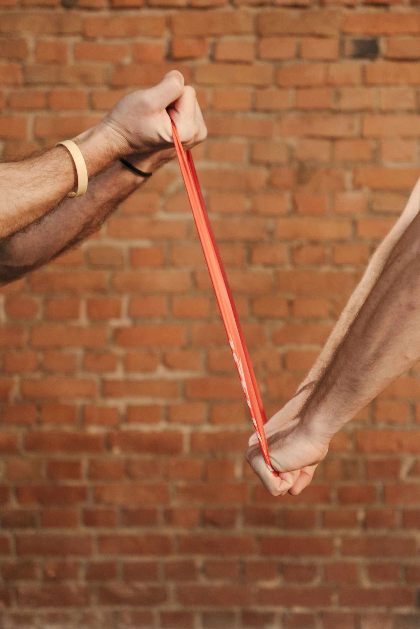 Close view of hands holding a red resistance band.
