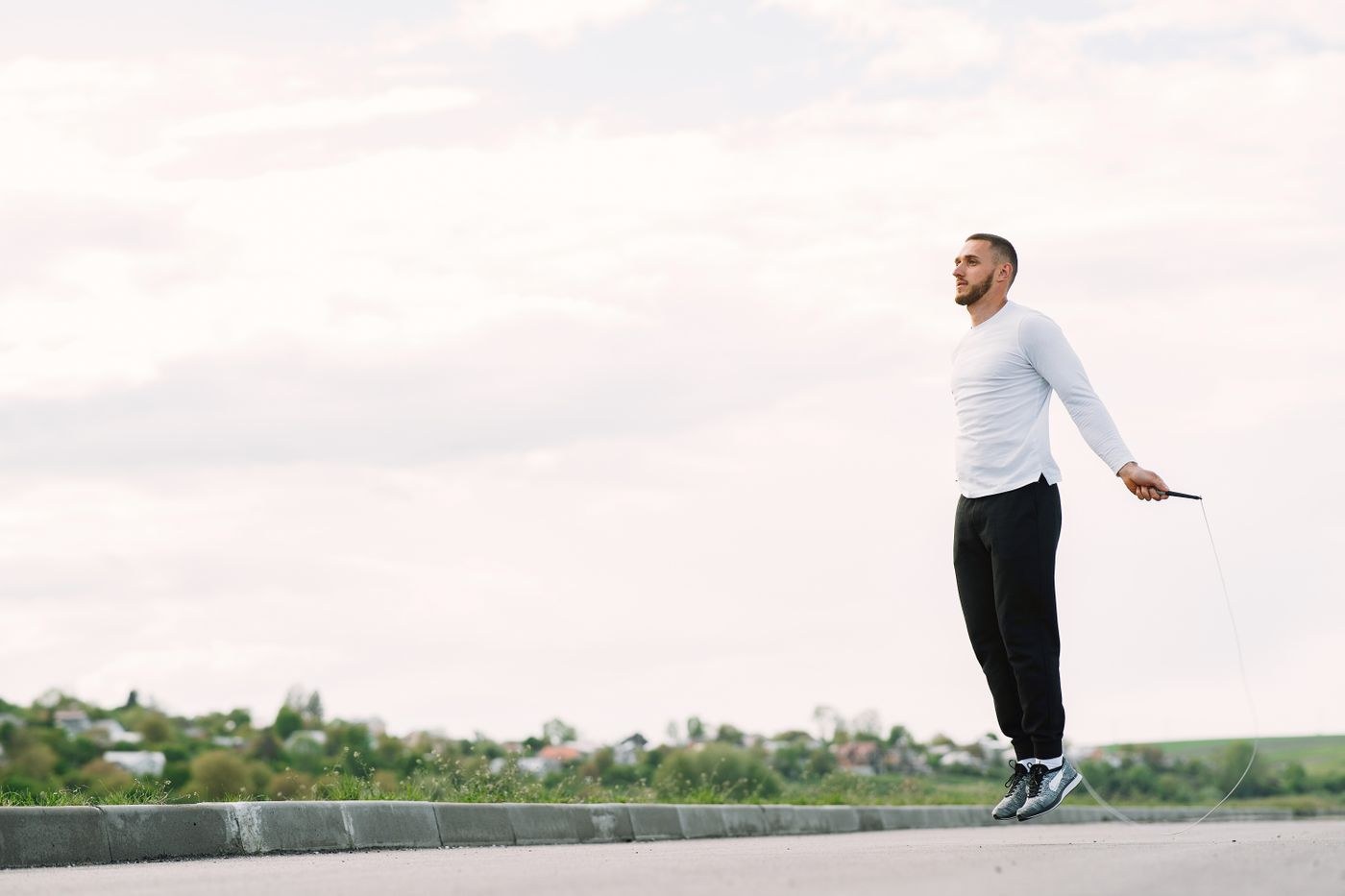 A man skipping in an open outdoor exercise space.