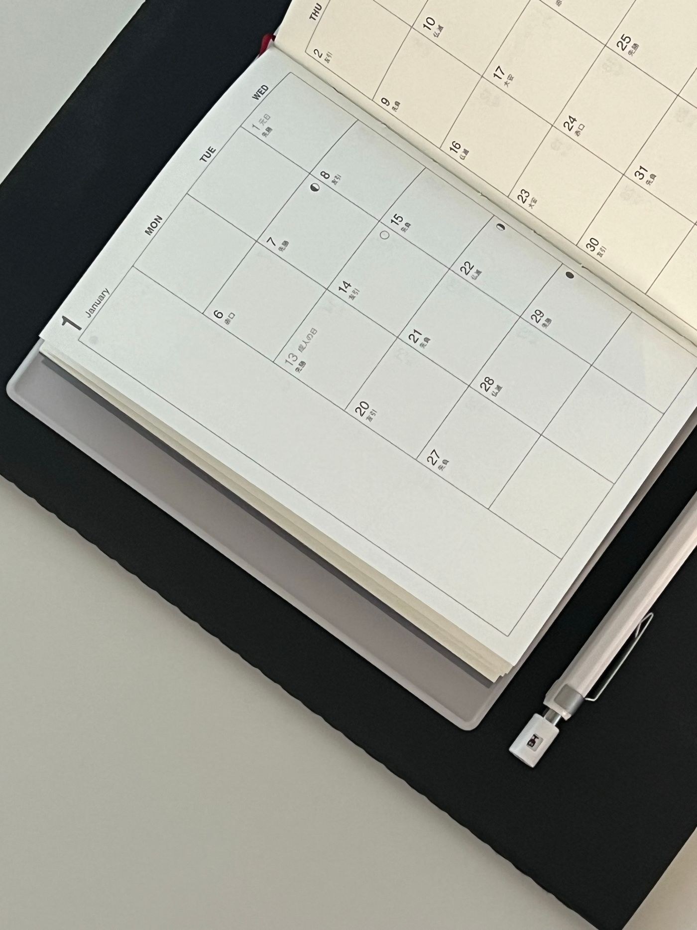An open monthly planner and pen ready for scheduling exercise slots.