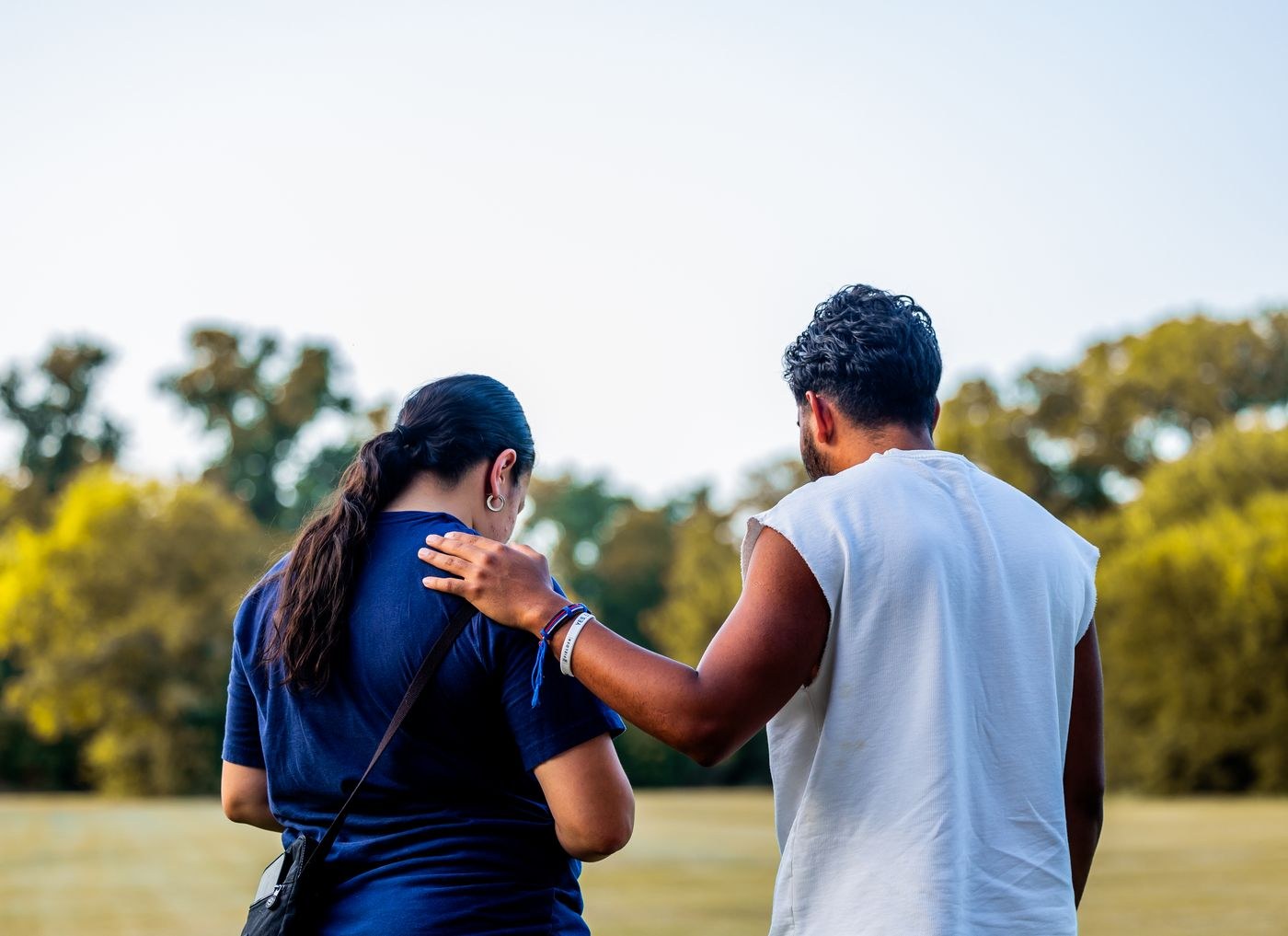 Two friends supporting each other during an outdoor walk.